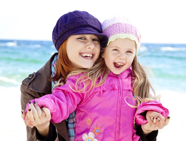 Twee zussen 4 en 21 jaar, oude op het strand in zonnige herfstdag. — Stockfoto