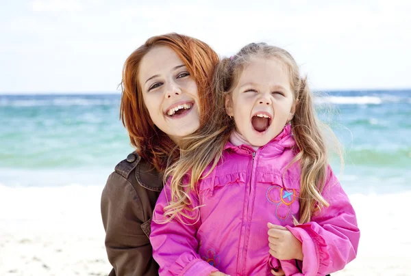 Twee zussen 4 en 21 jaar, oude op het strand in zonnige herfstdag. — Stockfoto