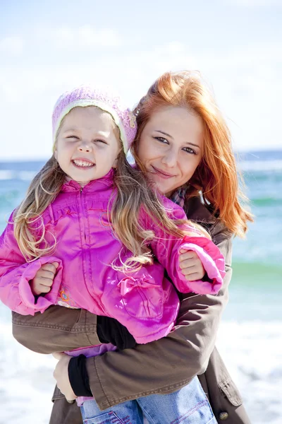 Dos hermanas de 4 y 21 años en la playa en el soleado día de otoño . — Foto de Stock