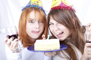 Two girlfriends with cake and wine celebrate 21th birthday clipart