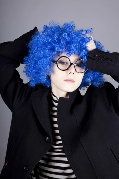 Funny modré vlasy dívka v brýle a černý kabát. — Stock fotografie