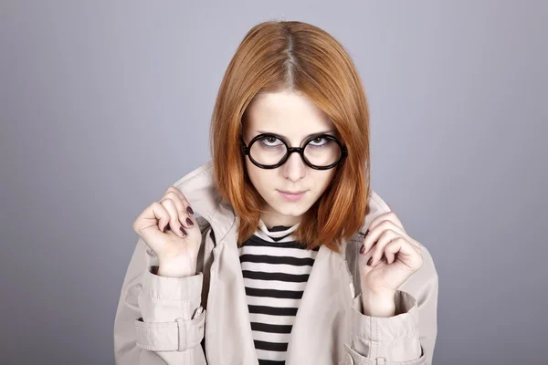Jeune fille aux cheveux roux en lunettes et manteau . — Photo
