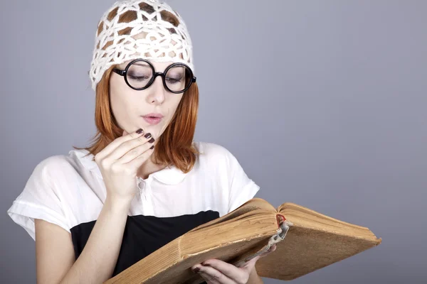 Roliga rödhårig tjej med gammal bok. — Stockfoto