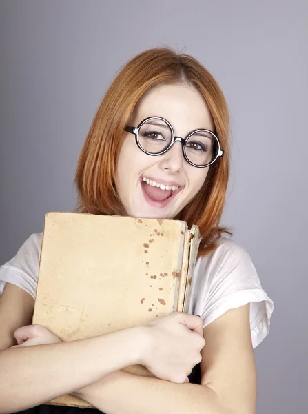 Lustige rothaarige Mädchen mit altem Buch. — Stockfoto