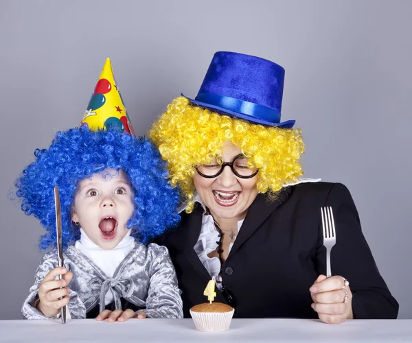 Madre e hijo en pelucas divertidas y pastel en el cumpleaños. Captura de estudio —  Fotos de Stock