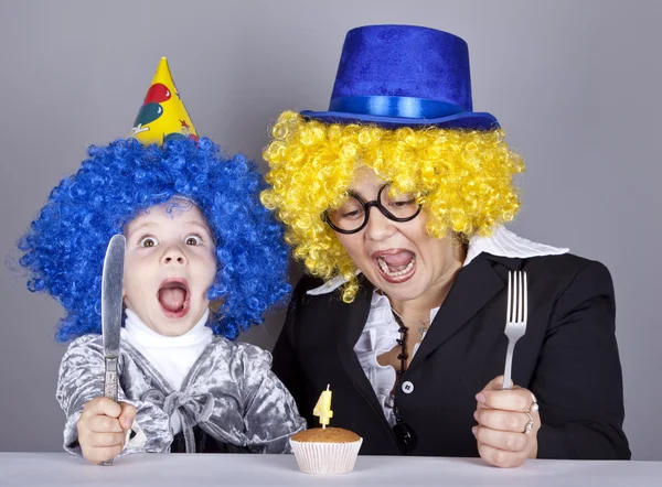 Mãe e criança em perucas engraçadas e bolo no aniversário. Estúdio — Fotografia de Stock