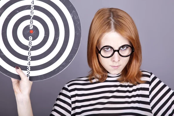 Angry red-haired girl with dartboard. — Stock Photo, Image