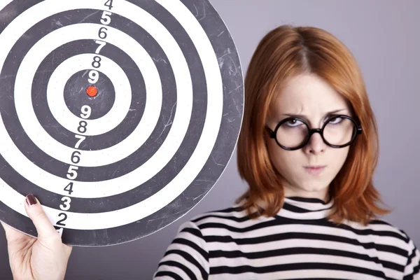 Angry red-haired girl with dartboard. — Stock Photo, Image