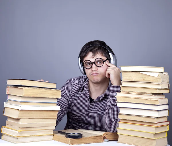 De jonge student met de boeken en de hoofdtelefoon geïsoleerd. — Stockfoto