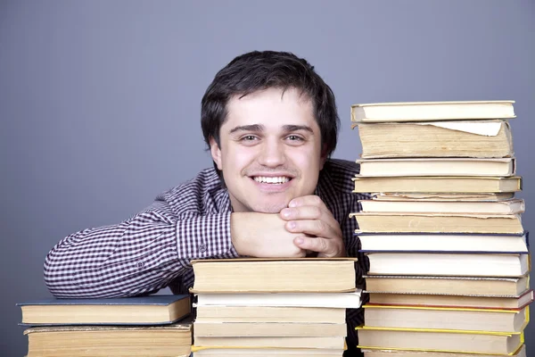 Młody student uśmiechający się z książek na białym tle. — Zdjęcie stockowe