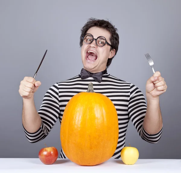 The young mad men try to eat two apples and pumpkin. — Stock Photo, Image