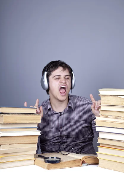 Den unga studerande med böcker och hörlurar isolerade. — Stockfoto