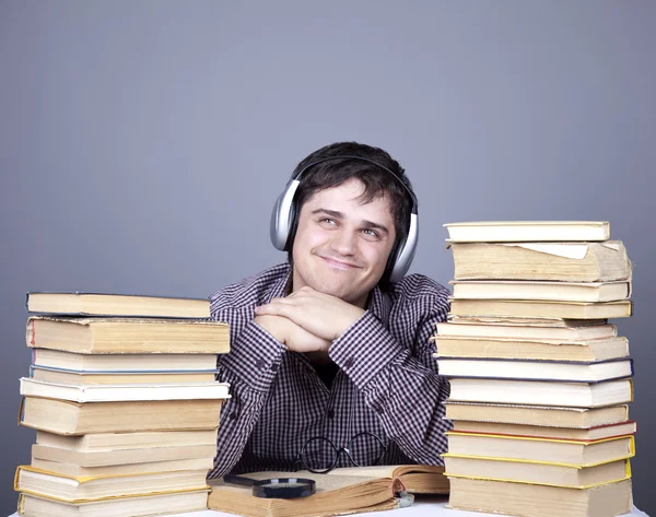 De jonge student met de boeken en de hoofdtelefoon geïsoleerd. — Stockfoto