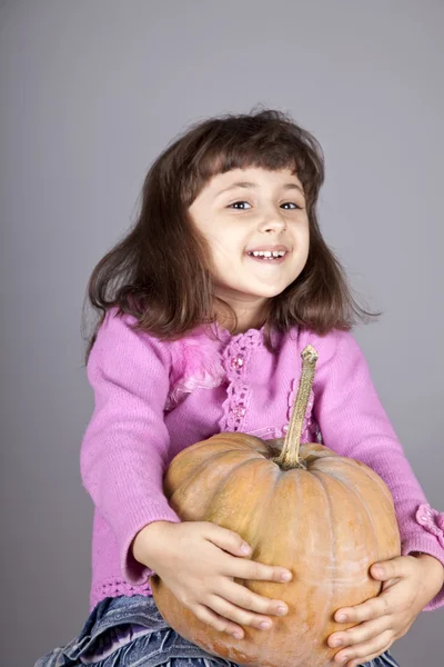 Smiling little girl with pumpkin. — Stock Photo, Image