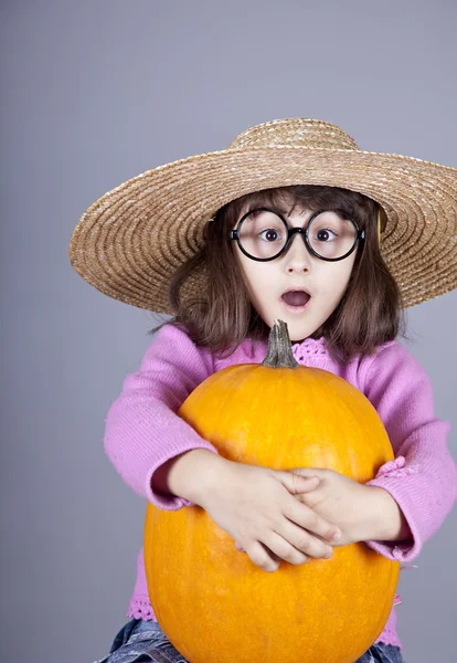 Menina engraçada em boné e óculos mantendo abóbora . — Fotografia de Stock
