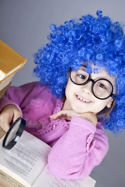 Lustiges blauhaariges Mädchen mit Lupe und Büchern. — Stockfoto