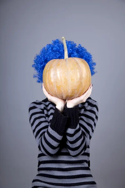 Lustiges Mädchen mit blauen Haaren hält Kürbis. — Stockfoto