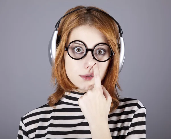Rolig tjej med hörlurar och glasögon. — Stockfoto