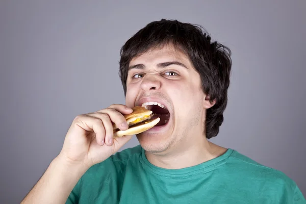 Aranyos fiú eszik hamburgert. — Stock Fotó