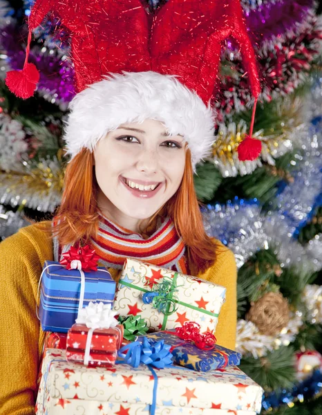 Legrační dívka v vánoční čepice s dárkové krabičky — Stock fotografie