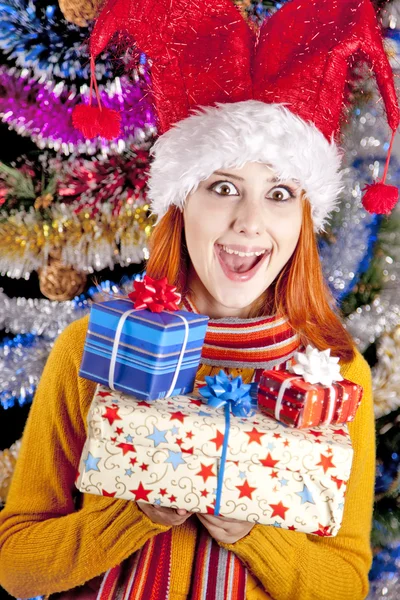 Grappig meisje in Kerstmis cap met geschenkdozen — Stockfoto