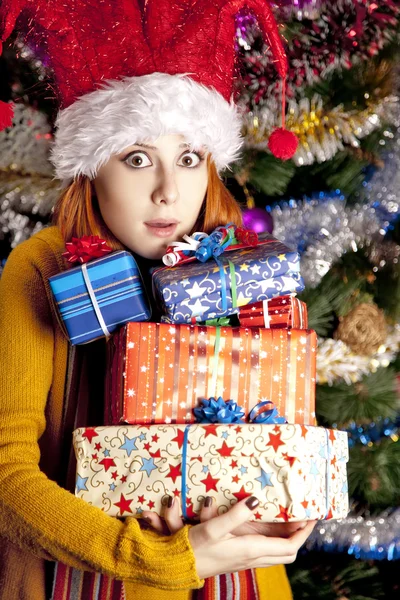 Hediye kutuları ile Noel şapkalı kız — Stok fotoğraf
