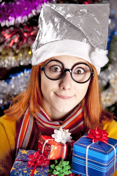 Lustiges Mädchen in Weihnachtsmütze mit Geschenkschachteln — Stockfoto
