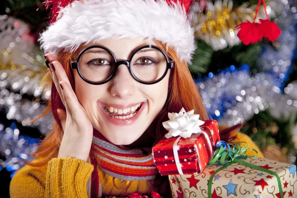 Chica divertida en gorra de Navidad con cajas de regalo — Foto de Stock