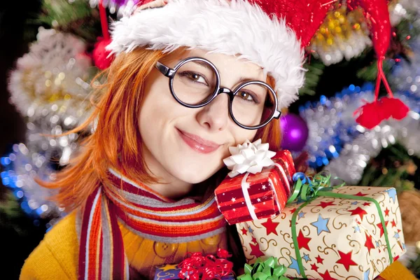 Funny girl in christmas cap with gift boxes — Stock Photo, Image