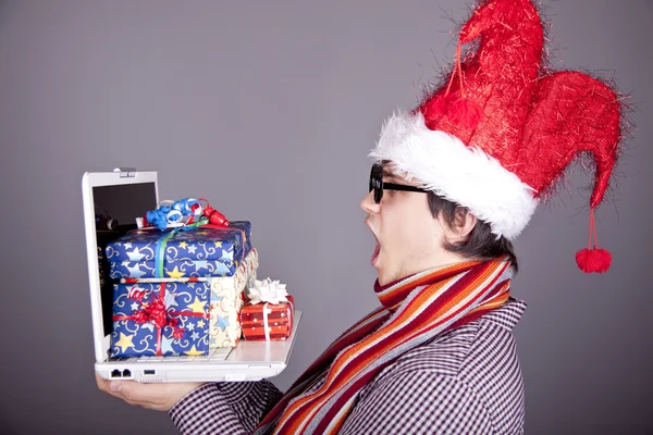 Uomini divertenti in cappello di Natale con scatole regalo e notebook . — Foto Stock