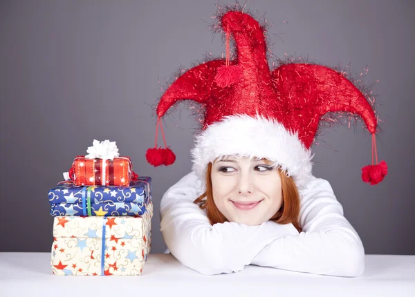 クリスマス キャップやギフト用の箱とメガネの女の子. — ストック写真