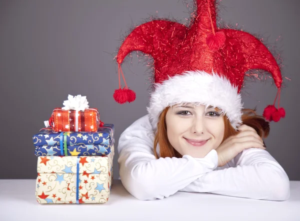 クリスマス キャップやギフト用の箱とメガネの女の子. — ストック写真