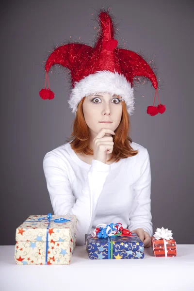 Девушка в рождественской кепке и очках с подарочными коробками . — стоковое фото