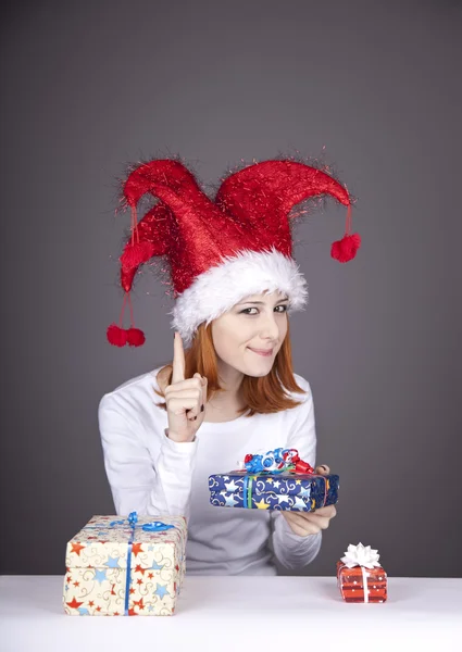 Chica en gorra de Navidad y vasos con cajas de regalo . —  Fotos de Stock
