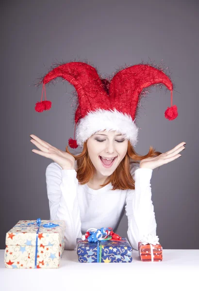 Kız Noel şapka ve gözlük hediye kutuları ile. — Stok fotoğraf