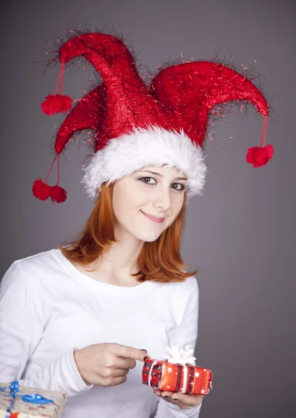 Dívka v vánoční čepici a brýle s dárkové krabičky. — Stock fotografie