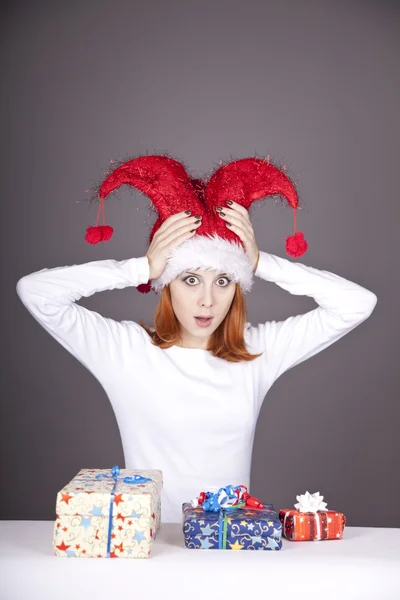 Девушка в рождественской кепке и очках с подарочными коробками . — стоковое фото