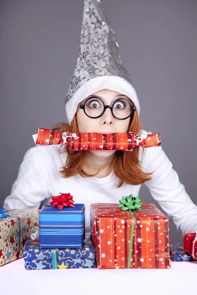 Ragazza in cappello di Natale e bicchieri con scatole regalo . — Foto Stock