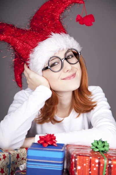 Дівчина в різдвяній шапці і окулярах з подарунковими коробками . — стокове фото