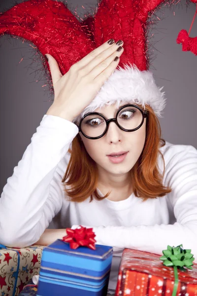 Menina em boné de Natal e óculos com caixas de presente . — Fotografia de Stock