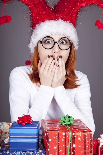 圣诞帽及礼品盒戴眼镜的女孩. — 图库照片