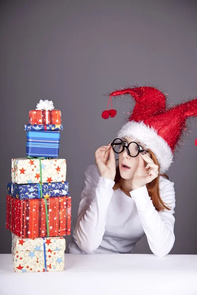 Menina em boné de Natal e óculos com caixas de presente . — Fotografia de Stock