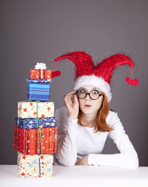 圣诞帽及礼品盒戴眼镜的女孩. — 图库照片