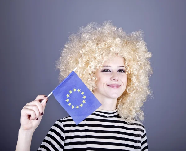 Vacker flicka med korkskruvar visar Europeiska unionens flagga. — Stockfoto