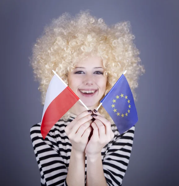 Hermosa chica con bucles muestran la bandera de la Unión Europea y Polonia — Foto de Stock