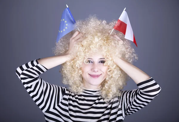 Vacker flicka med korkskruvar visar Europeiska unionen och Polen flagga — Stockfoto