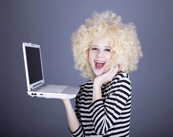 Портрет смешной девушки в блондинистом парике с ноутбуком . — стоковое фото
