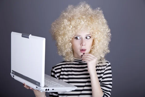 Porträtt av rolig flicka i blond peruk med laptop. — Stockfoto
