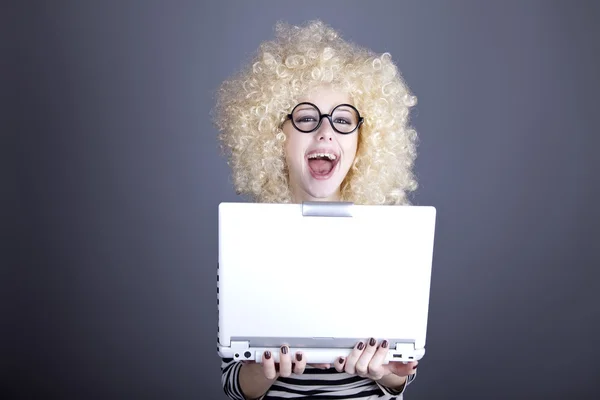 Ritratto di ragazza divertente in parrucca bionda con computer portatile . — Foto Stock