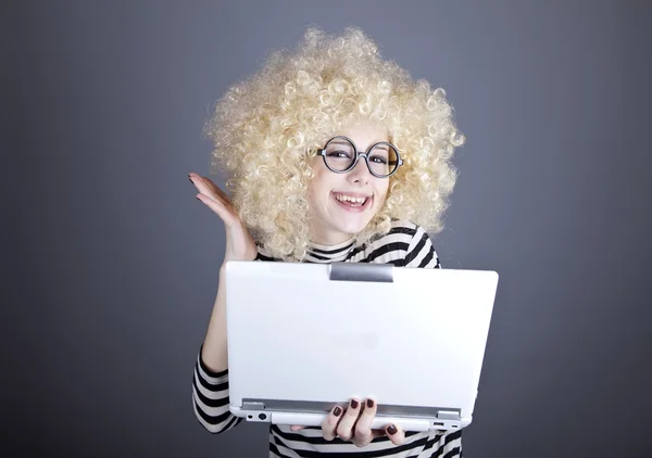 Portrait de fille drôle en perruque blonde avec ordinateur portable . — Photo
